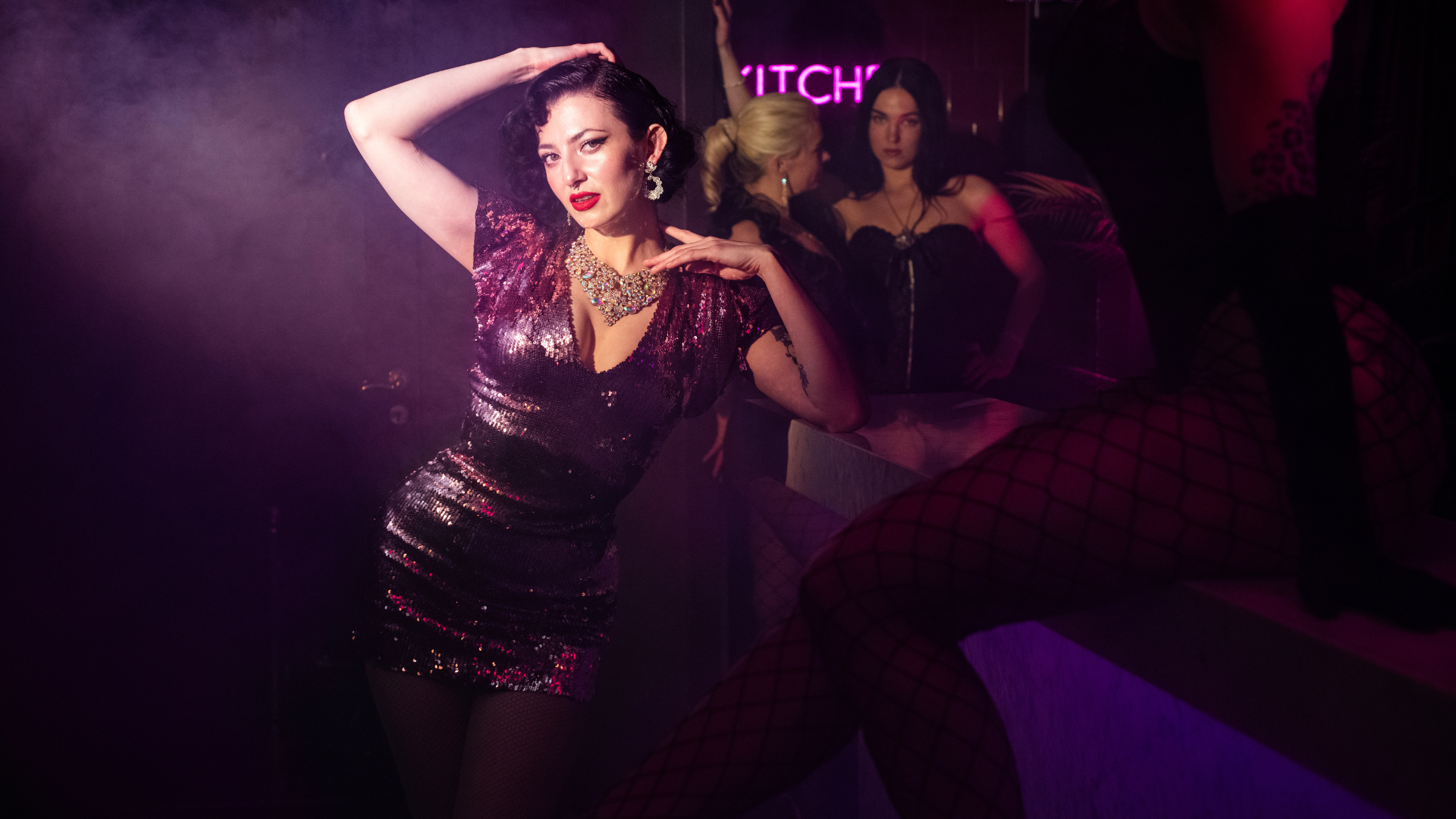 A beautiful dancer performing on stage at Velvet Room's burlesque show, with other performers in the background, creating an elegant and captivating atmosphere in Stockholm.