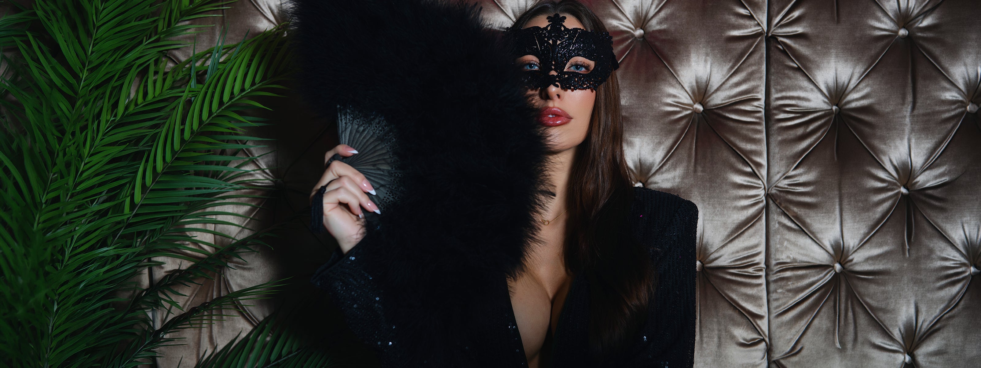 Kvinna med maskeradmask och fjäderfläkt i exklusiv nattklubbsmiljö på Velvetroom i Stockholm.