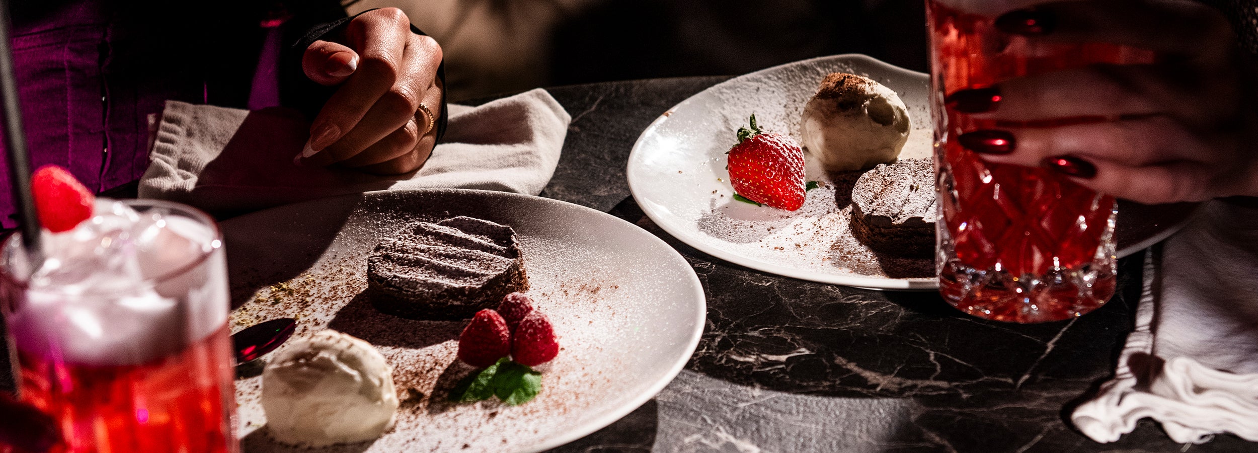 Dessert med chokladkaka, glass och bär serverad vid bord med cocktails på nattklubben Velvetroom i Stockholm.