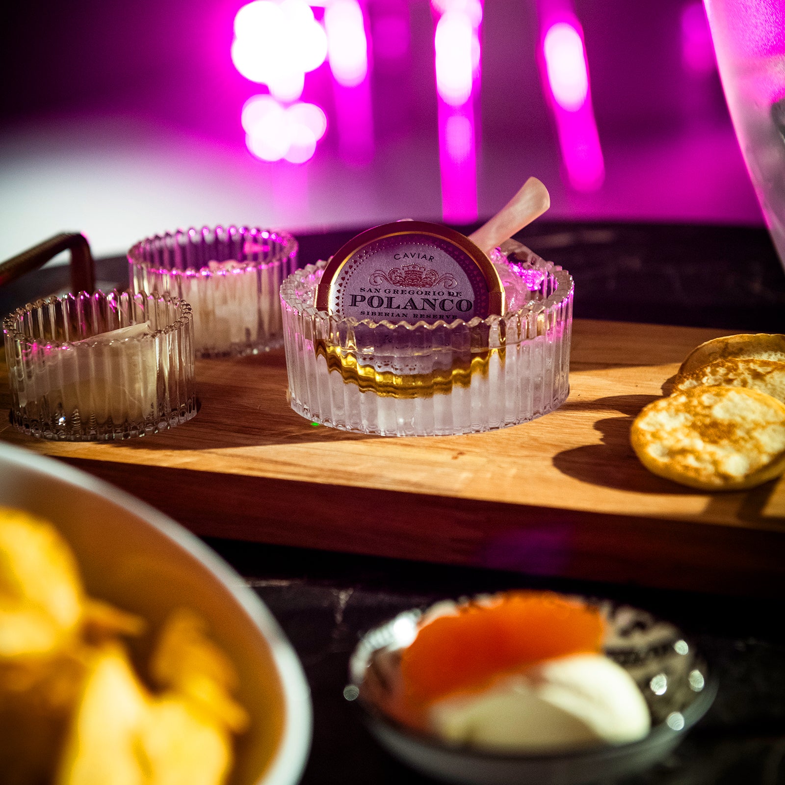 Lyxig kaviarservering med tillbehör i exklusiv nattklubbsmiljö på Velvetroom i Stockholm.