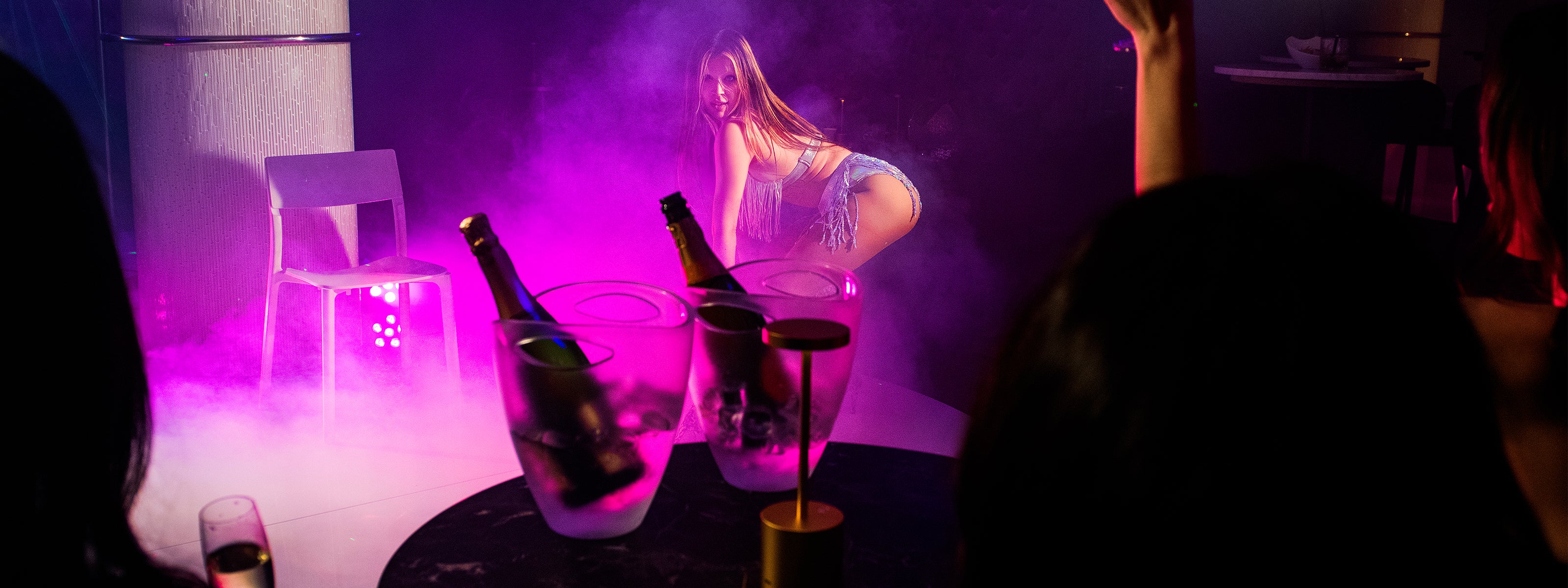 Dansare uppträder på scen framför VIP-bord med champagne på nattklubben Velvetroom i Stockholm.