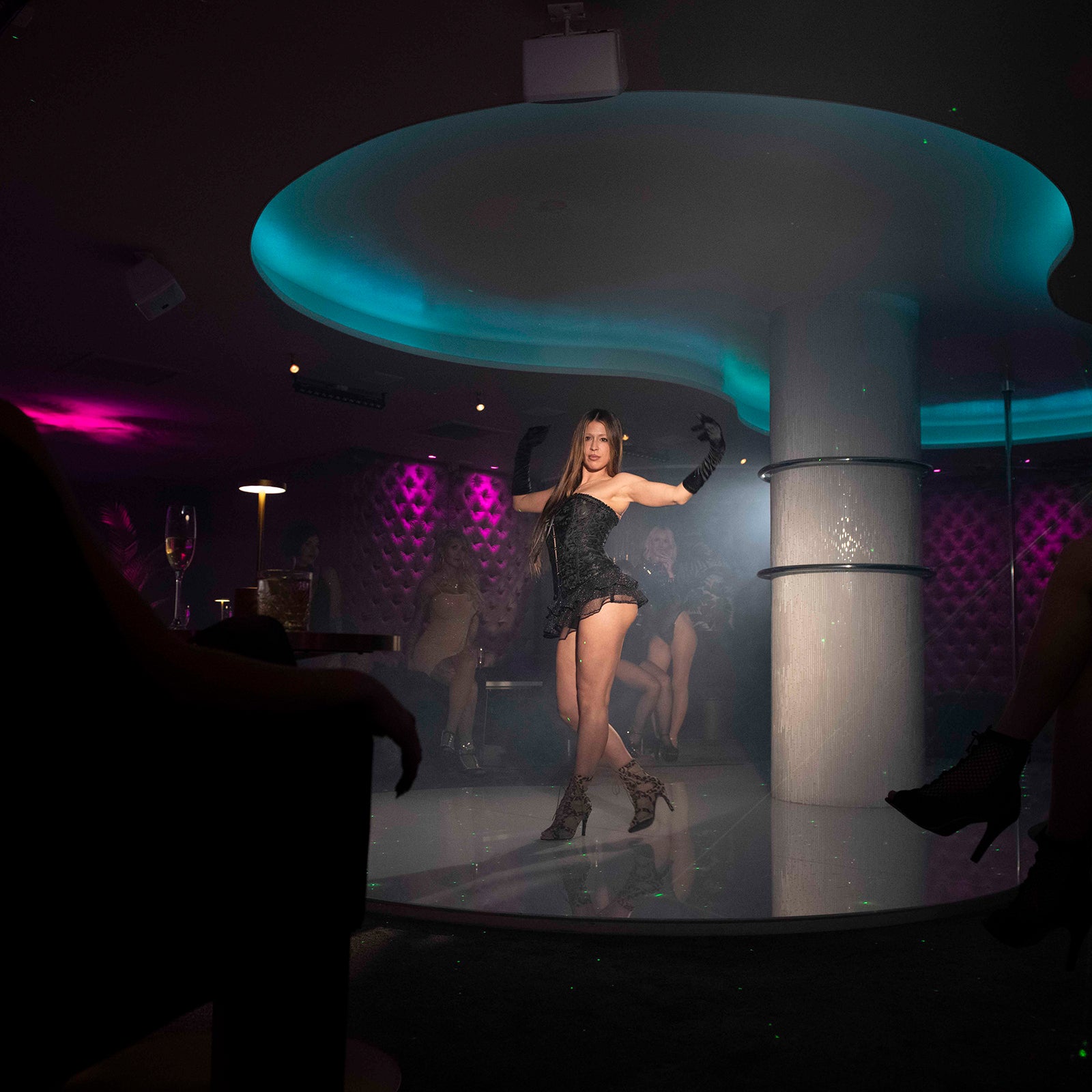 Showdansare uppträder på scen framför gäster i exklusiv nattklubbsmiljö på Velvetroom i Stockholm.