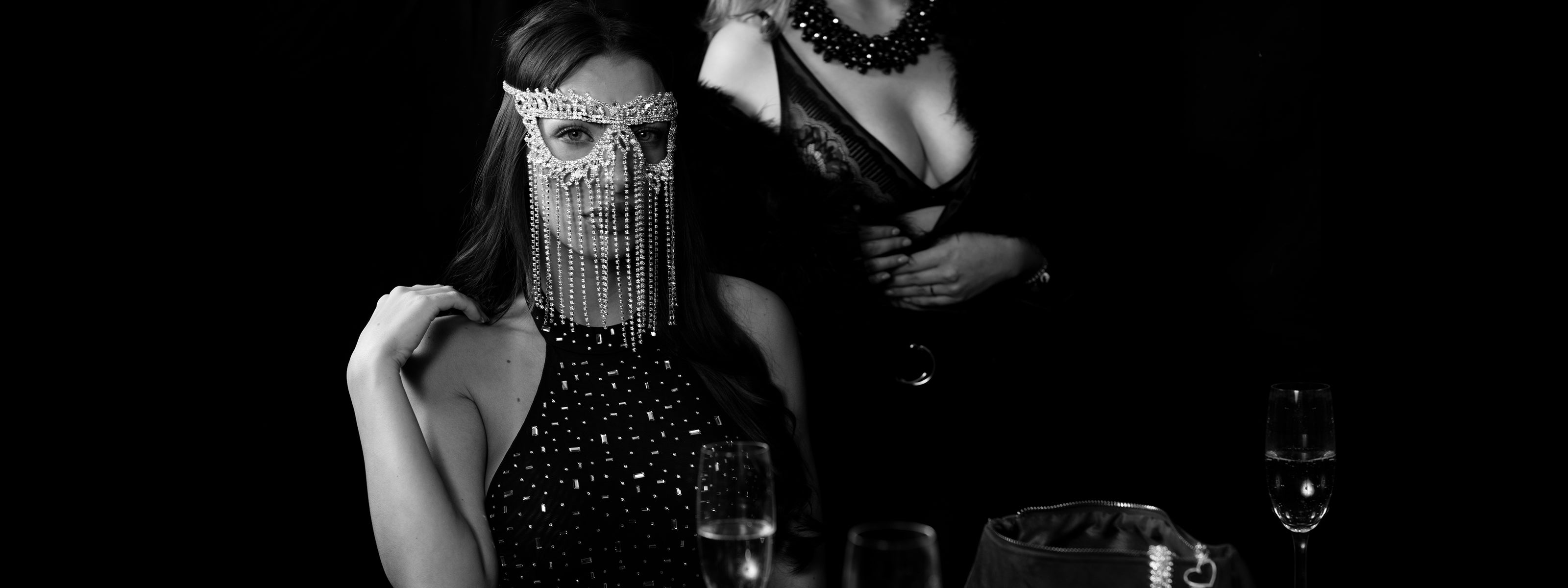 Elegant kvinna med kristallmask vid VIP-bord med champagne på nattklubben Velvetroom i Stockholm.