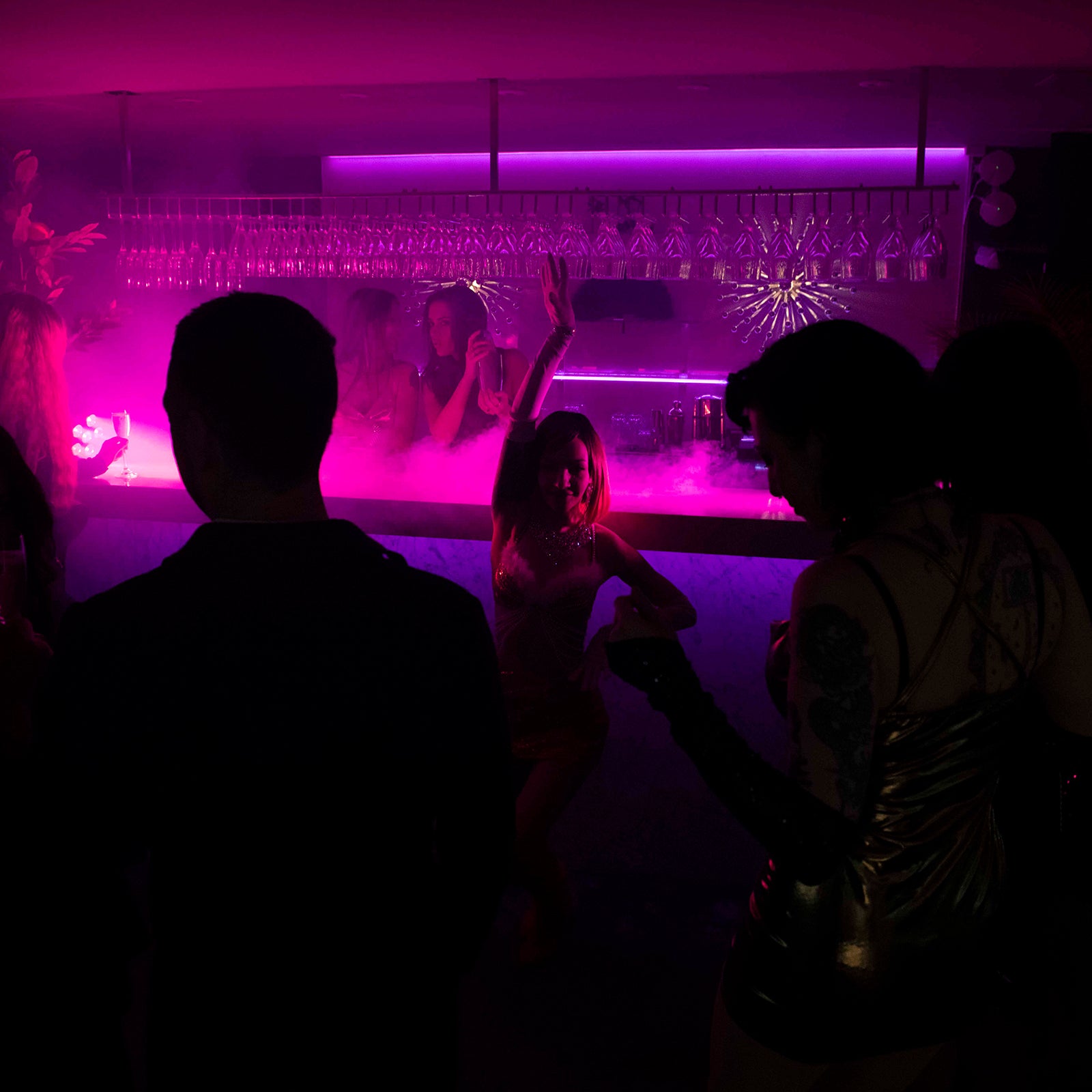 Dansare uppträder framför baren medan gäster festar på nattklubben Velvetroom i Stockholm.