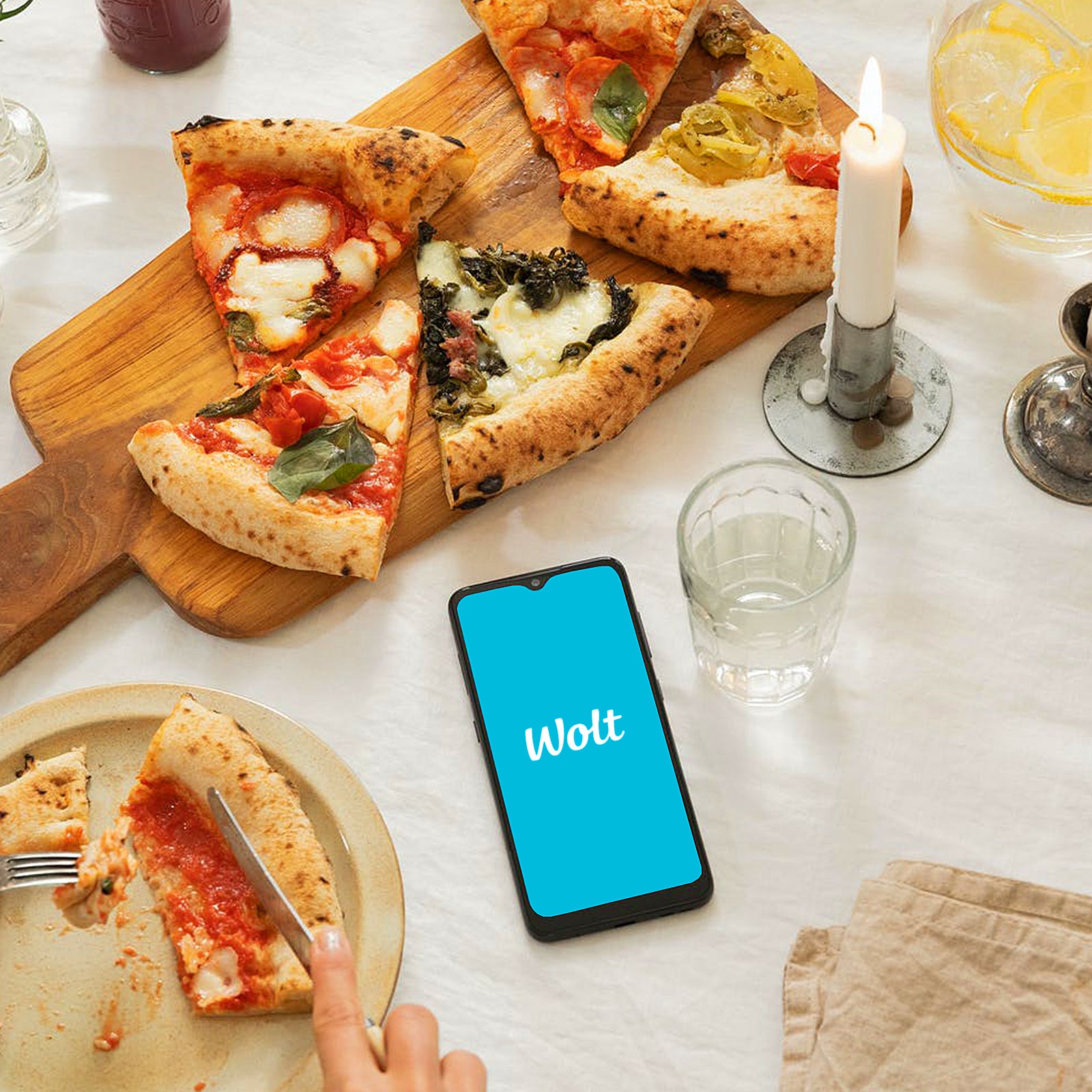 Pizza på bord med mobil som visar Wolt för matbeställning kopplat till Velvetroom i Stockholm.